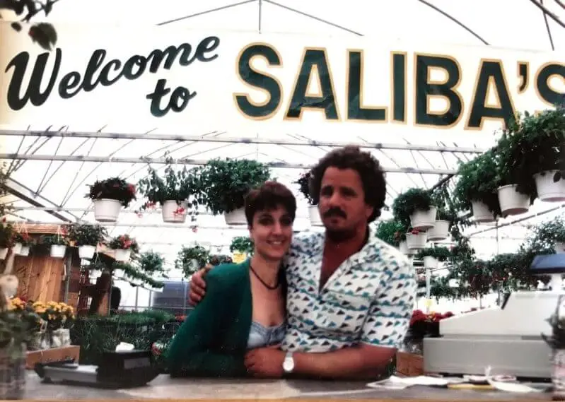 Couple posing at Saliba's greenhouse entrance.