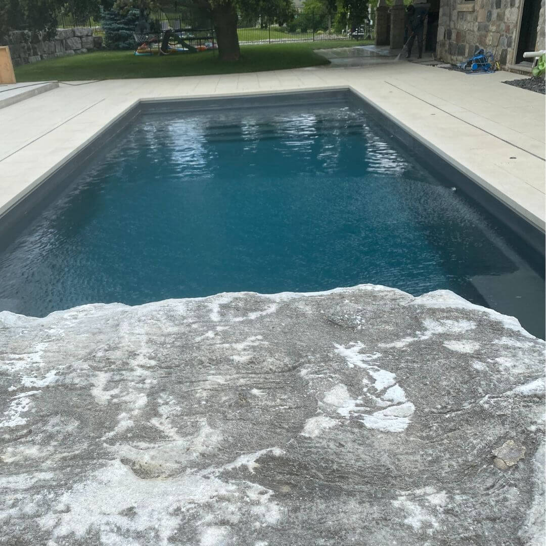 backyard pool with armorstone landscaping