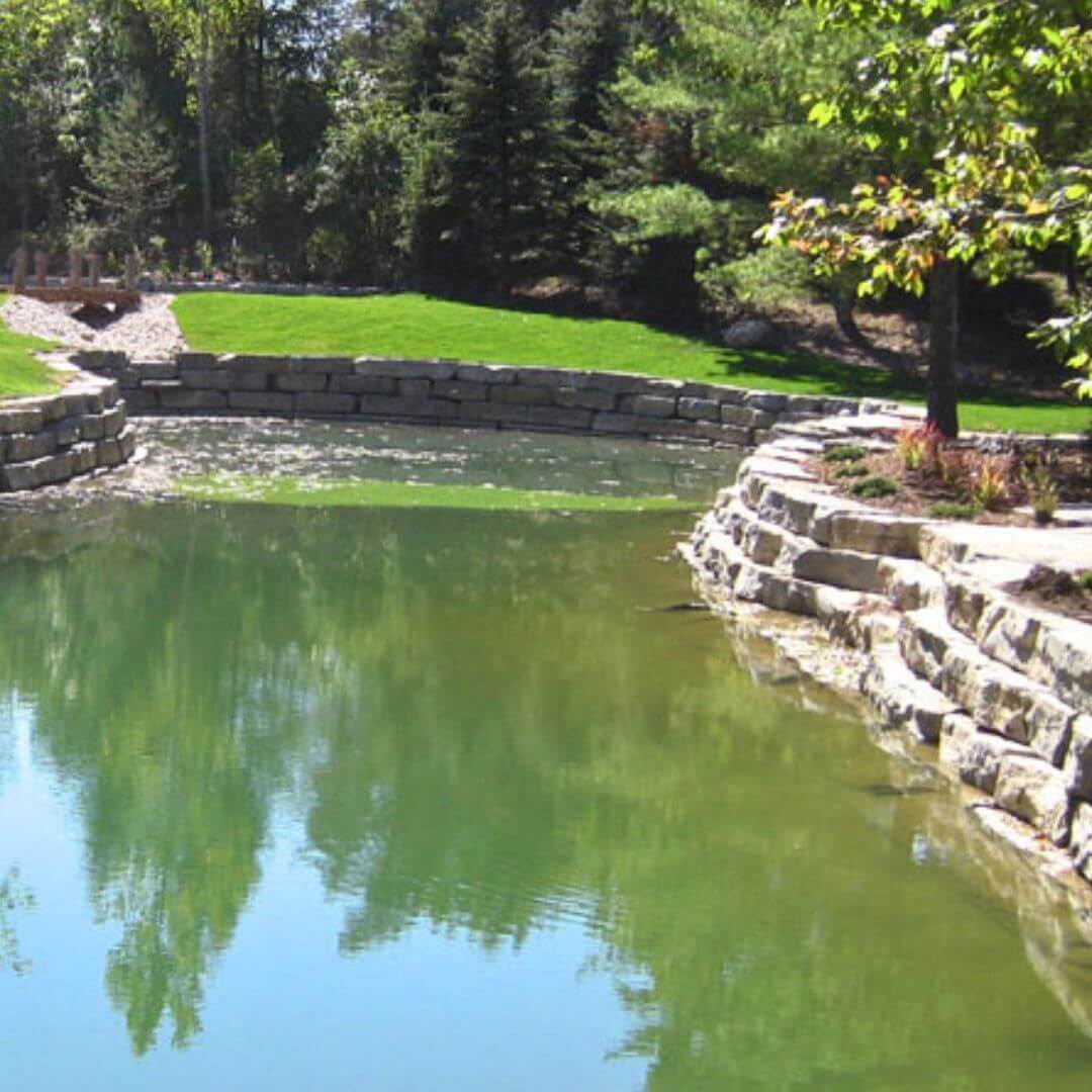 backyard pond installation in guelph with armorstone retaining wall